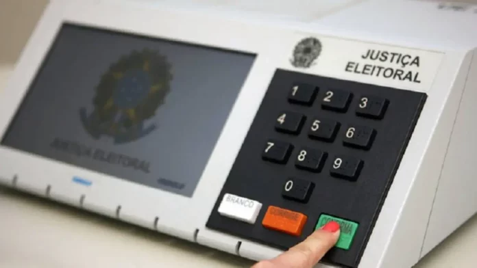 urna-1200x675 Eleitor pressiona a tecla confirma de uma urna eletrônica, em imagem que ilustra a suspensão da divulgação dos resultados das eleições pelo TSE após decisão do STF.